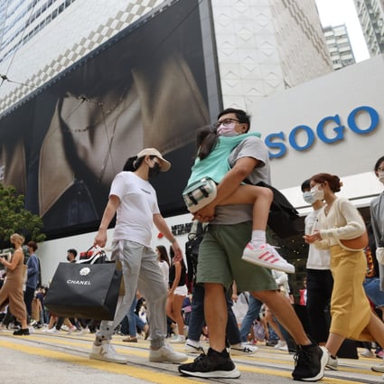 People are seen crossing the road in Causeway Bay, where popular department store Sogo stands as a retailing landmark, on April 17, 2022. Photo: Nora Tam