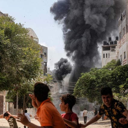 People run for cover during an Israeli aerial bombardment in Gaza City. Photo: AFP