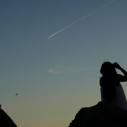 A woman looks at a Chinese People’s Liberation Army aircraft flying over Pingtan island, one of mainland China’s closest points to Taiwan, on August 5. Photo: Reuters
