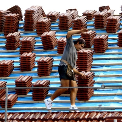 A roof tiler balances on a roof at a residential building site in Sydney on August 1. Photo: Reuters