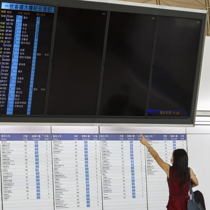 A woman checks departing flight at Hong Kong airport on August 8. Photo: K.Y. Cheng