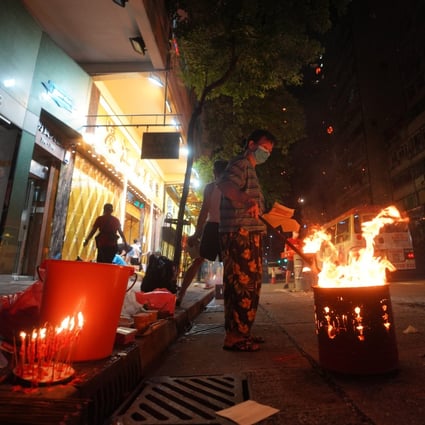 A woman burns offerings on the street during Hungry Ghost Festival. Some other customs during the festival, however, aren’t necessarily grounded in tradition. Photo: Winson Wong