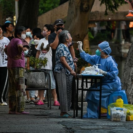 A health worker takes a swab sample from a woman to test for Covid-19 in Shanghai. Photo: AFP