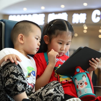 Two children play video games on a tablet at an airport in Xian, China. Photo: Shutterstock