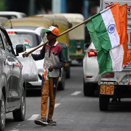 A boy on a New Delhi road sells Indian national flags for the nation’s 75th Independence Day. Photo: AFP
