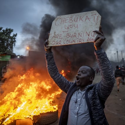 A supporter of presidential candidate Raila Odinga, next to a roadblock of burning tires in the Kibera neighborhood of Nairobi, Kenya. Photo: AP