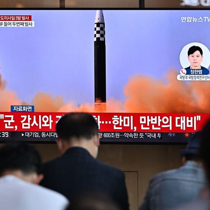 People watch a television screen showing a news broadcast with file footage of a North Korean missile test at a railway station in Seoul. Photo: AFP/Getty Images/TNS