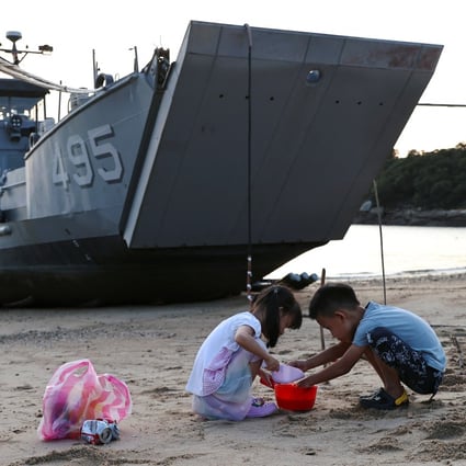 Children play with sand near a Taiwan navy supply ship at a beach on Nangan island of Matsu archipelago on August 16. Photo: Reuters