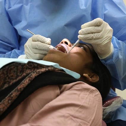 A dentist attends to a patient at the Prince Philip Dental Hospital in Sai Ying Pun in January 2020. Photo: K.Y. Cheng