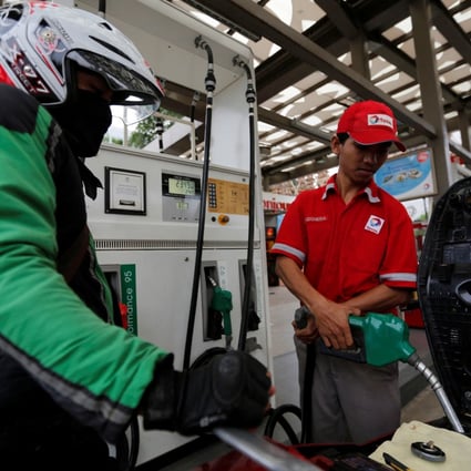 A petrol station employee fills up a motorcycle for a customer in Jakarta. File photo: Reuters