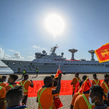 Workers wave the Chinese and Sri Lankan national flags as the Yuan Wang 5 docks at Hambantota port on Tuesday. Photo: AFP
