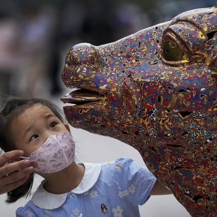A child takes a look at a bull sculpture in Beijing. Photo: AP Photo