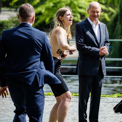Topless Women Protest Beside Germanys Olaf Scholz In Call For Russian 