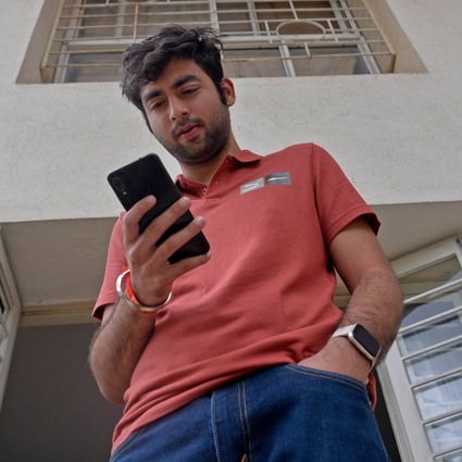 Pranay Pathole uses his mobile phone at his home in Pune, India. Photo: AFP