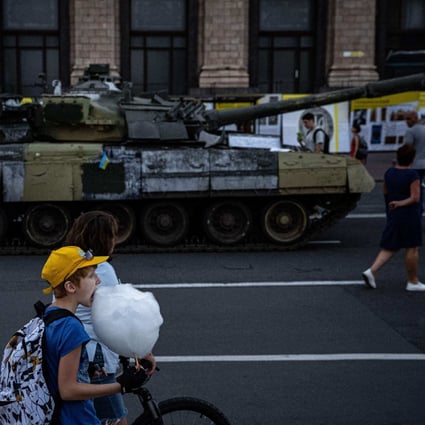 A boy eats candy floss next to a destroyed Russian tank displayed on Khreshchatyk Street, in Kyiv, on August 23. The street was turned into an open-air military museum ahead of Ukraine’s Independence Day on August 24. Photo: AFP