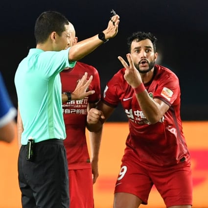 Henrique Dourado (second right) of Henan SSLM speaks with the referee during a Chinese Super League match against Wuhan Three Towns. Photos: Xinhua