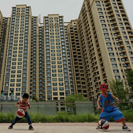 Children play in front of a housing complex by Chinese property developer Evergrande in Beijing on July 28. After years of explosive growth, authorities launched a crackdown on excessive debt in 2020, squeezing financing options for property sector giants such as Evergrande as they struggled to make repayments and restructure mountains of debt. Now they face mortgage boycotts and government pressure to deliver pre-sold homes. Photo: AFP