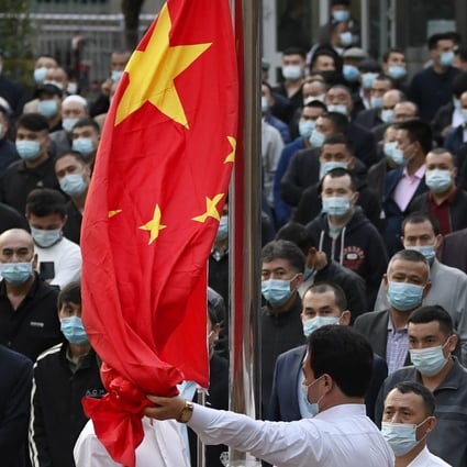 People watching China’s national flag being raised at a mosque in Urumqi in Xinjiang Uygur autonomous region last year. Photo: Kyodo
