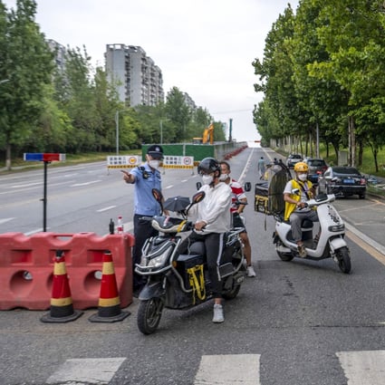 Police officers in Chengdu, China perform checks on a road ahead of a Covid-19 lockdown on Thursday. Photo: AFP