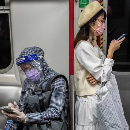 People wearing face masks to prevent COVID-19 commute on a train in Hong Kong on March 2, 2022. Rules for travelers in Hong Kong are changing: The previous seven-day quarantine hotel arrangement for those with COVID will be replaced by three days in a quarantine hotel and four days of home medical surveillance. (Dale De La Rey/AFP via Getty Images/TNS)