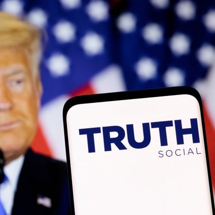The Truth social network logo seen on a smartphone in front of a display of former US president Donald Trump in this picture illustration taken February 21, 2022. Photo: Reuters