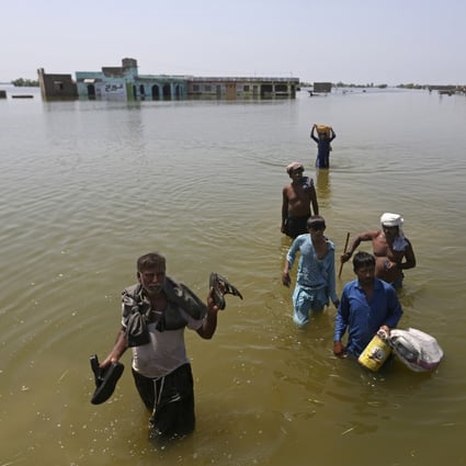 Victims of flooding carry belongings salvaged from their homes in Pakistan on Thursday. The deluge, which began in mid-June, has triggered landslides and collapsed houses, killing over 1,350 people including hundreds of children, and leaving more than 600,000 homeless. Photo: AP