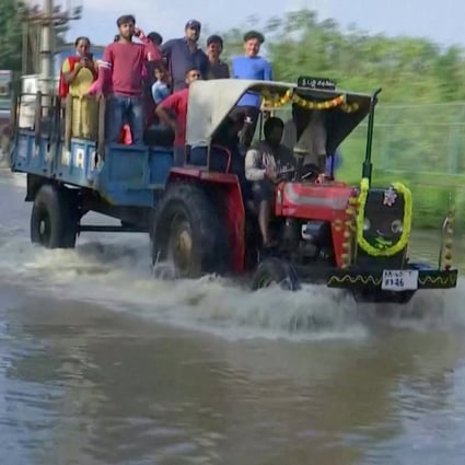 People commute in a tractor following torrential rains in Bangalore on Tuesday. Photo: Reuters