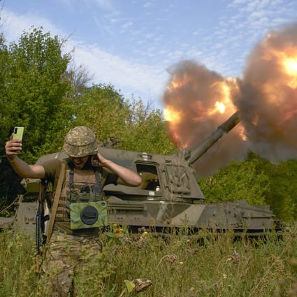 A Ukrainian soldier takes a selfie as an artillery system fires in Donetsk region, eastern Ukraine. Photo: AP