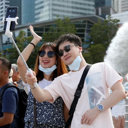 Tourists take a selfie in Singapore’s Merlion Park in January 2020. Photo: Reuters