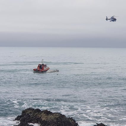 A helicopter and a rescue boat search for survivors off the coast of Kaikoura, New Zealand, on Saturday. Photo: AP