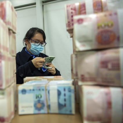 A clerk counts renminbi banknotes at a bank outlet in Hai’an city in eastern China’s Jiangsu province. Photo: AP