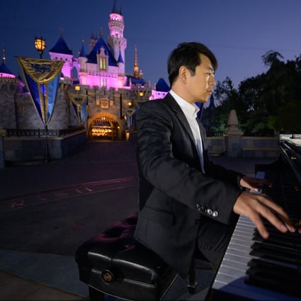 Lang Lang in front of the Sleeping Beauty Castle at the Disneyland Resort, California. He is promoting his new album The Disney Book, a collection of newly arranged theme songs. Photo: Richard Harbaugh
