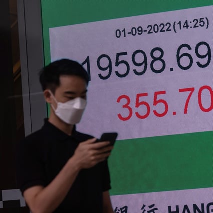 A man walks past a billboard showing the Hang Seng Index in Hong Kong on September 1, 2022. Photo: EPA-EFE