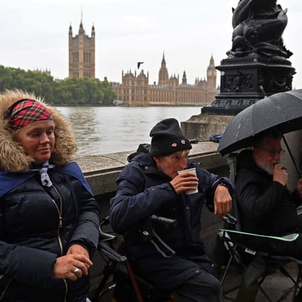 Members of the public queue in the rain along the south bank of the River Thames, as they wait to pay their respects when Queen Elizabeth lies in state. Photo: AFP