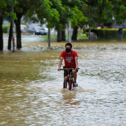 A man cycles through floodwaters in Batu Berendam in Malaysia’s southern coastal state of Malacca on January 3. Photo: AFP