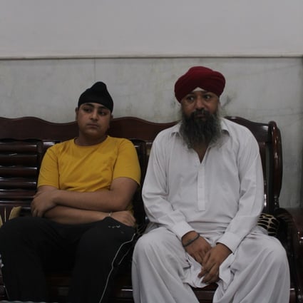 Manmohan Singh, 45, with his son Sandeep in New Delhi. The family has been looked after there by the Afghan refugee Sikh community since fleeing to India last month. Photo: Bilal Kuchay