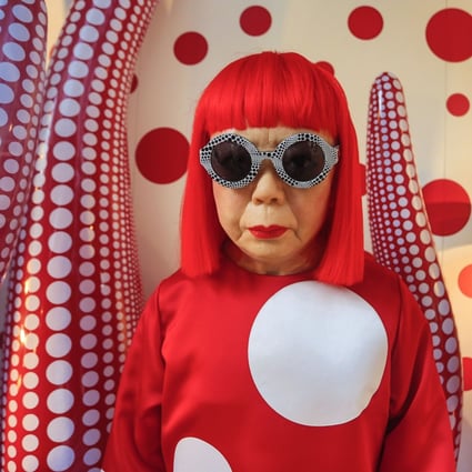 Yayoi Kusama poses against one of her works featuring her signature polka dot motif in Hong Kong in 2012. au milieu de son oeuvre à Hong Kong, Photo:  Jose-Fuste Raga/Gamma-Rapho via 
 Getty Images