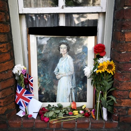 A picture of Britain’s Queen Elizabeth and floral tributes displayed in a window in Windsor. Photo: AFP