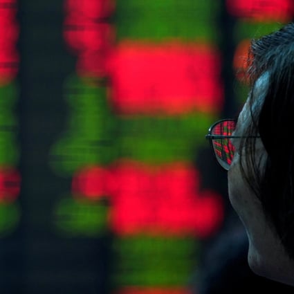 An investor looks at an electronic board showing stock information at a brokerage in Shanghai. Photo: Reuters