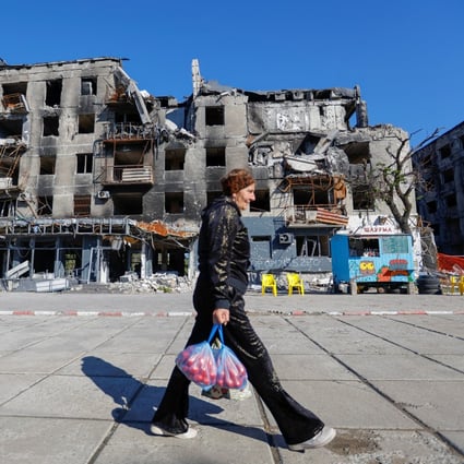 A local resident walks past a block of flats damaged in the course of Russia-Ukraine conflict in Mariupol, Ukraine on Sunday. Photo: Reuters