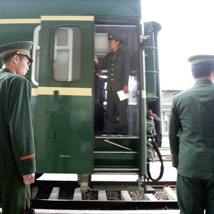 A North Korean railway guard stands aboard a train as it passes Chinese military police officers in Dandong in 2004. Photo: AP