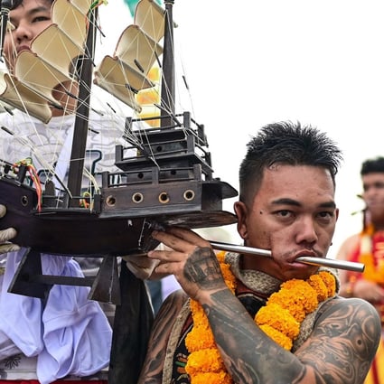 A devotee with a ship model pierced through his cheek waits to take part in a procession during the annual Vegetarian Festival in Phuket. Photo: AFP