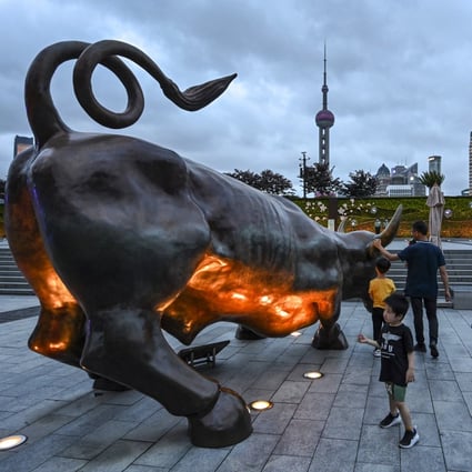 People next to a bull sculpture on the Bund in Shanghai on June 9, 2021. The city accounted for more than a third of IPO funds raised so far in 2022, according to EY. Photo: AFP