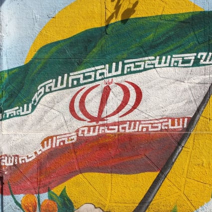 Iranians ride past painting of Iran’s flag on a wall in Tehran on Tuesday. Photo: EPA-EFE