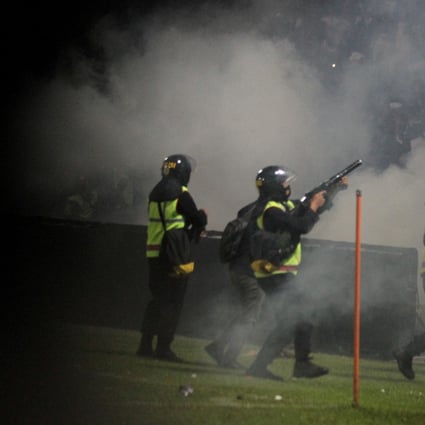 A riot police officer fires tear gas during a after a football match between Arema vs Persebaya at Kanjuruhan Stadium in Malang, East Java province, Indonesia on Sunday. Photo: Antara Foto/Ari Bowo Sucipto/via Reuters