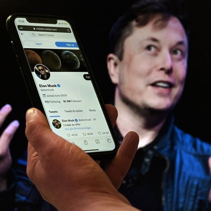In this photo illustration, a phone screen displays the Twitter account of Elon Musk with a photo of him shown in the background, on April 14, 2022. Photo: AFP