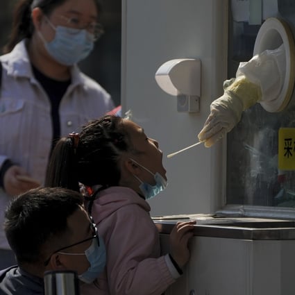A child gets her routine Covid-19 throat swab at a coronavirus testing site in Beijing on Thursday. Photo: AP Photo