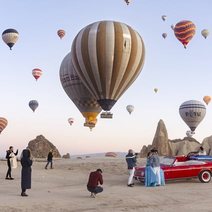 An image from photographer Natacha de Mahieu’s new series “Theatre of Authenticity” of Cappadocia, in Türkiye, where thousands of travellers jostle for space each morning to take selfies and pose on vintage cars. Photo: Natacha de Mahieu