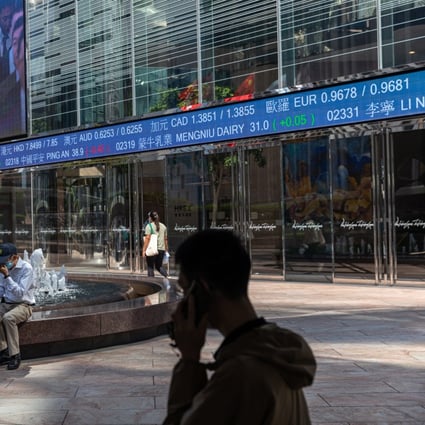 Pedestrians walk past a stock ticker displaying the Hang Seng Index in Hong Kong on October 11. Photo: EPA-EFE