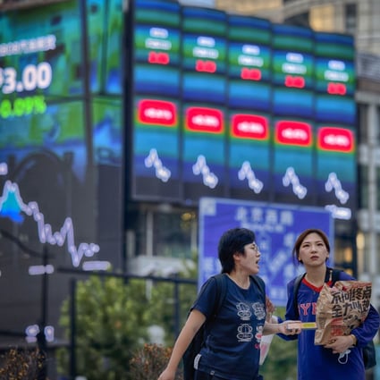 People walk in front of a screen showing stock exchange data in Shanghai. Chinese onshore listed companies are set to report third-quarter results this month. Photo:   EPA-EFE